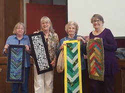 Janice Tuinstra, Norma Womack, Phyllis Calvert, Penny Ruddle showing off serger group table tunners