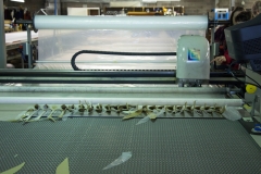 Computer-operated cutter...doing little plastic bits for hats.  This table has suction to keep the fabric, marker, and plastic flat